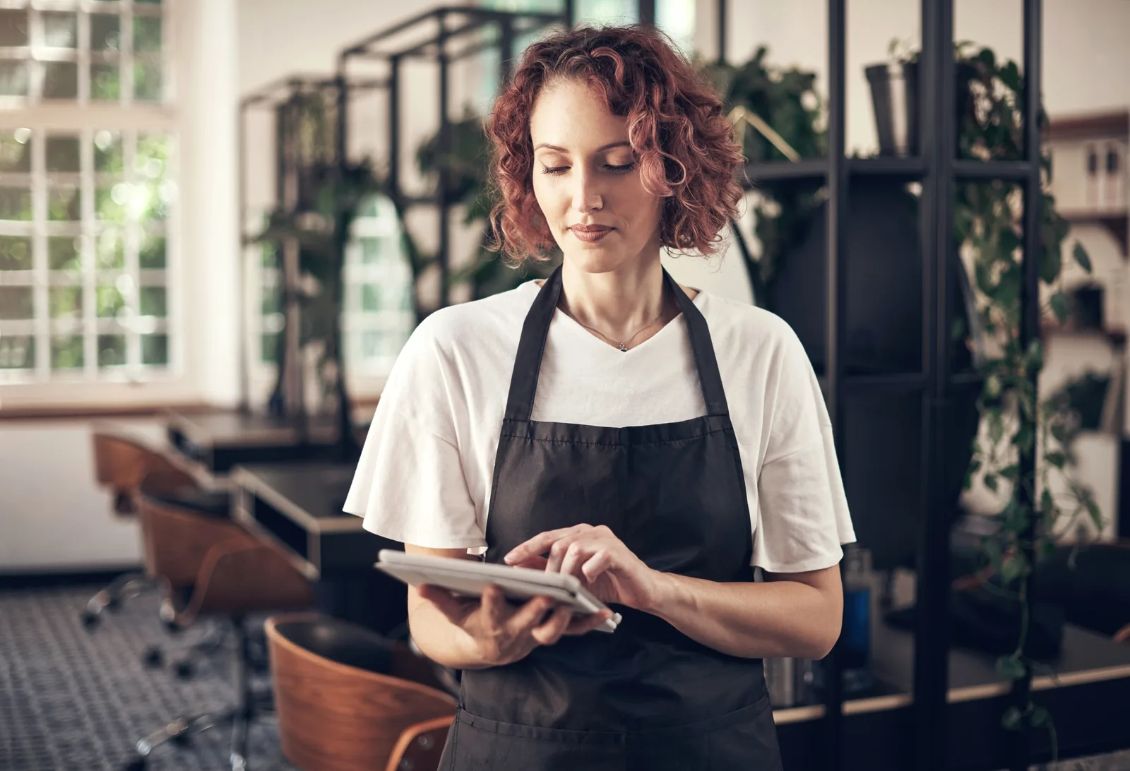 Profesional consultando reservas en su tablet en el salón